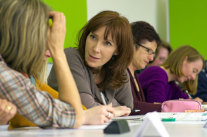 Frauen im Seminar besprechen sich und machen Notizen