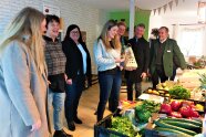 Mehrere Personen stehen vor Gemüsekisten
