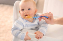 Baby isst Brei von Plastiklöffel